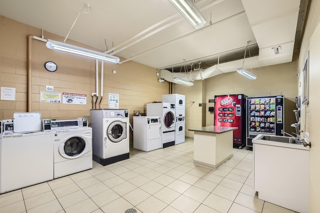 3041 S Michigan Ave Unit 501, Chicago, IL 60616 - shared laundry room with independent washer and dryer, concrete block wall, and light tile patterned floors