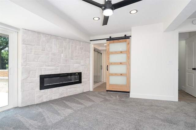 1717 Liston Ct, Normal, IL 61761 - unfurnished living room with carpet floors, a barn door, a stone fireplace, ceiling fan, and recessed lighting