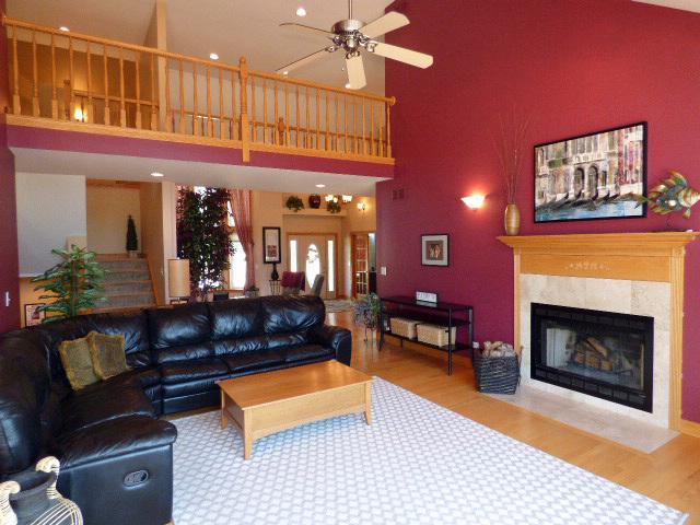 41W951 Hunters Hill Dr, Saint Charles, IL 60175 - living area with wood finished floors, a high ceiling, a ceiling fan, a fireplace with flush hearth, and stairway