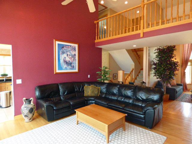 41W951 Hunters Hill Dr, Saint Charles, IL 60175 - living room featuring wood finished floors, stairs, a ceiling fan, plenty of natural light, and a high ceiling