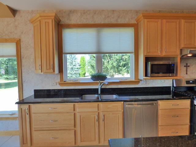 41W951 Hunters Hill Dr, Saint Charles, IL 60175 - kitchen featuring appliances with stainless steel finishes, light brown cabinetry, wall chimney range hood, dark stone counters, and healthy amount of natural light