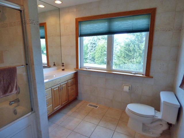 41W951 Hunters Hill Dr, Saint Charles, IL 60175 - bathroom featuring vanity, tile walls, tile patterned flooring, bath / shower combo with glass door, and recessed lighting