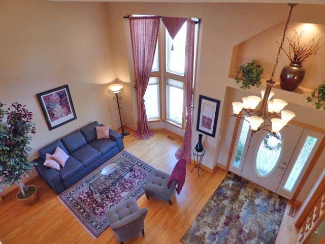 41W951 Hunters Hill Dr, Saint Charles, IL 60175 - living room with plenty of natural light, wood finished floors, a chandelier, and a towering ceiling