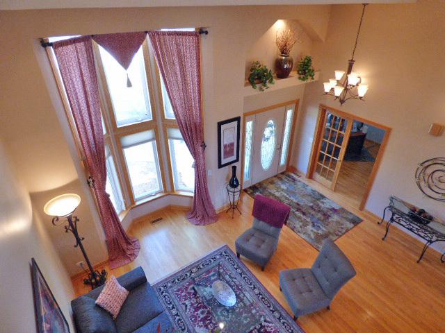 41W951 Hunters Hill Dr, Saint Charles, IL 60175 - living room with a high ceiling, a chandelier, and wood finished floors