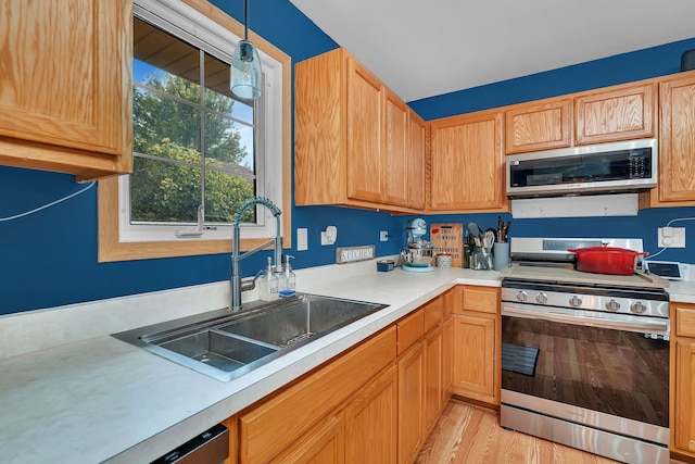 1308 Cumberland Dr, Joliet, IL 60431 - kitchen featuring stainless steel appliances, light countertops, light wood-style flooring, and pendant lighting