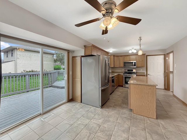 701 E Soper St, Winnebago, IL 61088 - kitchen featuring appliances with stainless steel finishes, ceiling fan, a kitchen island, and light tile patterned floors