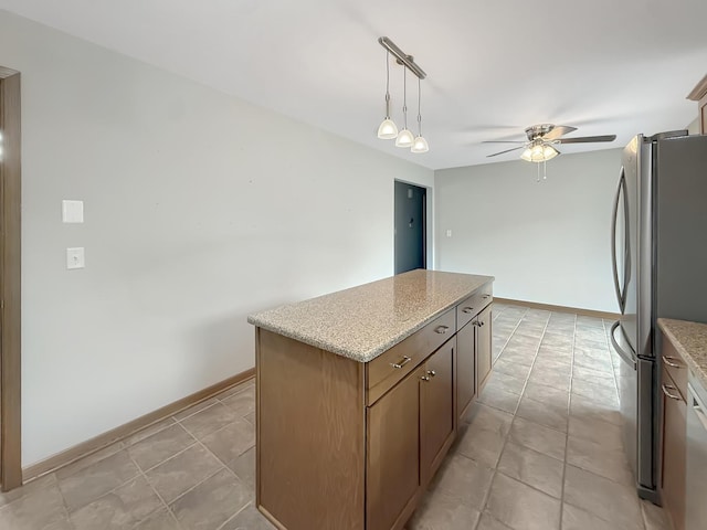 701 E Soper St, Winnebago, IL 61088 - kitchen with freestanding refrigerator, ceiling fan, a center island, hanging light fixtures, and light stone counters