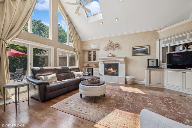 1881 Haven Ln, Green Oaks, IL 60048 - living room with high vaulted ceiling, wood-type flooring, a tiled fireplace, a ceiling fan, and crown molding