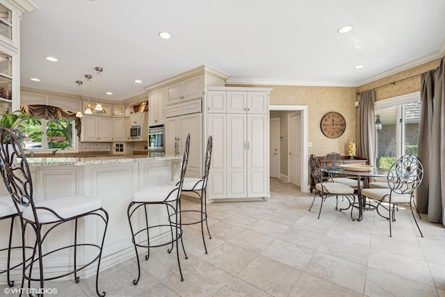 1881 Haven Ln, Green Oaks, IL 60048 - kitchen with cream cabinetry, stainless steel appliances, ornamental molding, light stone counters, and a breakfast bar area