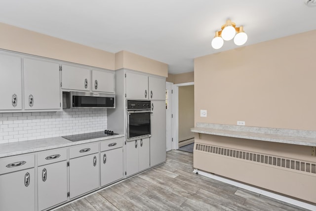 9613 S Kostner Ave, Oak Lawn, IL 60453 - kitchen featuring black appliances, radiator, light wood-type flooring, tasteful backsplash, and light countertops