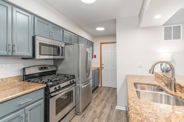 8306 Portsmouth Dr Unit 22B, Darien, IL 60561 - kitchen with appliances with stainless steel finishes, light wood finished floors, recessed lighting, and light stone counters