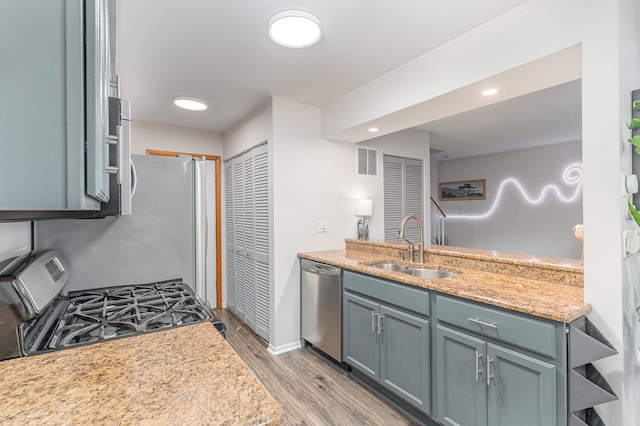 8306 Portsmouth Dr Unit 22B, Darien, IL 60561 - kitchen featuring stainless steel appliances, light wood-style flooring, and light stone counters