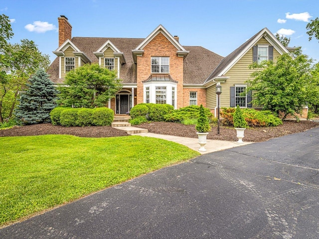 2207 N Elmkirk Pkwy N, Mchenry, IL 60051 - view of front of property with a chimney, a front yard, brick siding, and roof with shingles