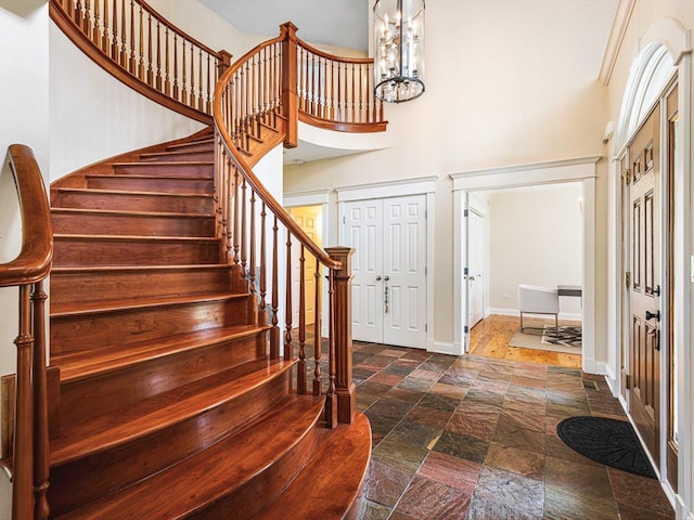2207 N Elmkirk Pkwy N, Mchenry, IL 60051 - entrance foyer with stone tile floors, stairway, a high ceiling, and a chandelier