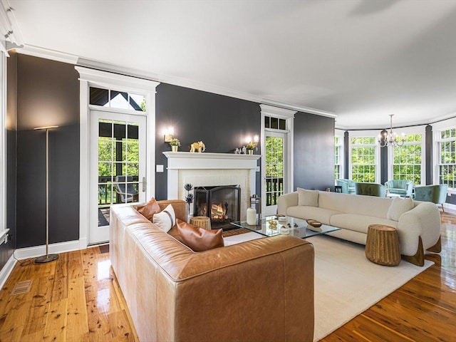 2207 N Elmkirk Pkwy N, Mchenry, IL 60051 - living room with a brick fireplace, light wood finished floors, ornamental molding, and a chandelier