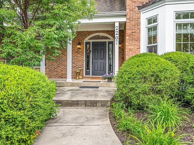 2207 N Elmkirk Pkwy N, Mchenry, IL 60051 - entrance to property with a porch, brick siding, and roof with shingles