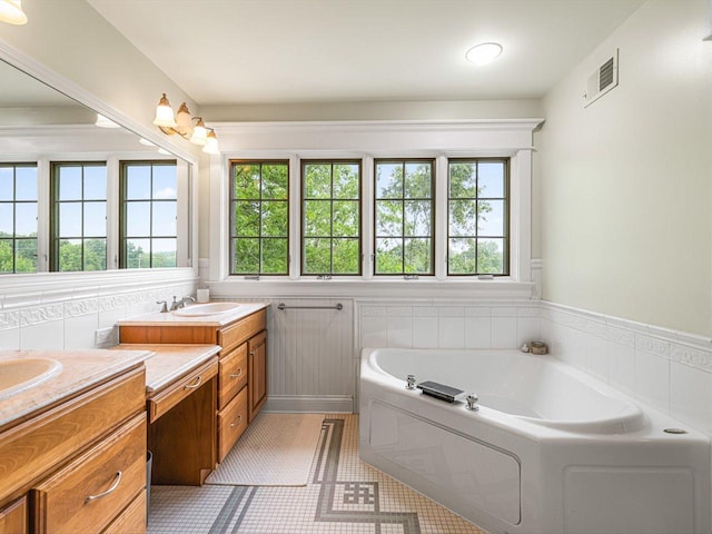 2207 N Elmkirk Pkwy N, Mchenry, IL 60051 - full bath with two vanities, healthy amount of natural light, a bath, and tile patterned flooring