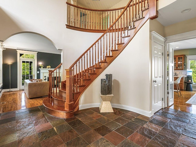 2207 N Elmkirk Pkwy N, Mchenry, IL 60051 - staircase with a high ceiling, arched walkways, plenty of natural light, and stone tile flooring