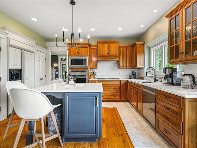 2207 N Elmkirk Pkwy N, Mchenry, IL 60051 - kitchen with built in appliances, light countertops, tasteful backsplash, a kitchen island, and light wood finished floors
