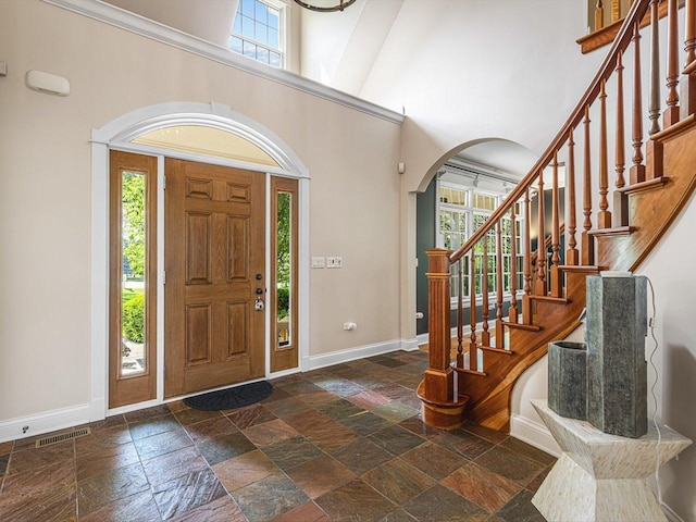 2207 N Elmkirk Pkwy N, Mchenry, IL 60051 - foyer featuring stone tile floors, a towering ceiling, arched walkways, and stairs