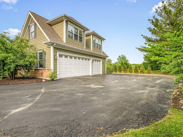 2207 N Elmkirk Pkwy N, Mchenry, IL 60051 - view of property exterior featuring asphalt driveway, a garage, brick siding, and roof with shingles