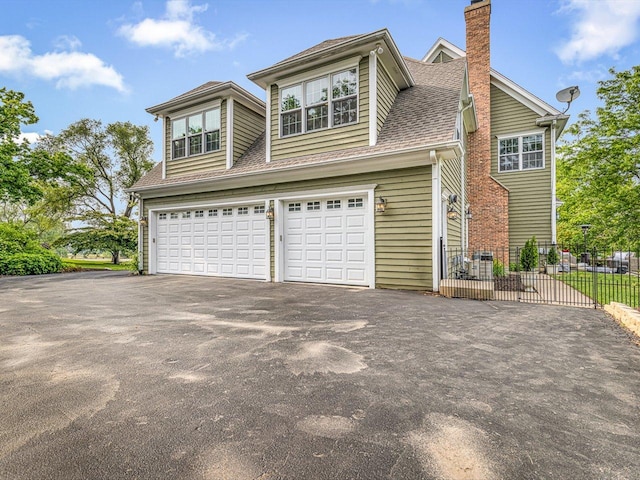 2207 N Elmkirk Pkwy N, Mchenry, IL 60051 - view of side of property with asphalt driveway, a chimney, a garage, and a shingled roof