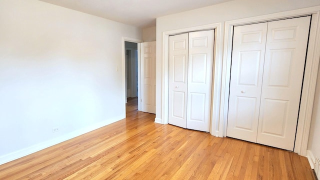 5448 N Washtenaw Ave, Chicago, IL 60625 - unfurnished bedroom with multiple closets and light wood-style flooring