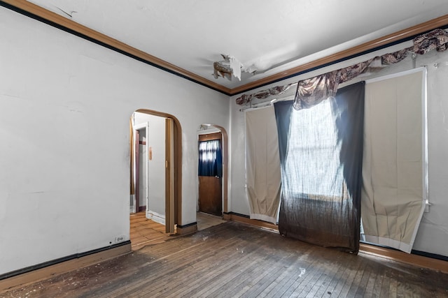 5212 S Honore St, Chicago, IL 60609 - empty room with arched walkways, wood-type flooring, and ornamental molding