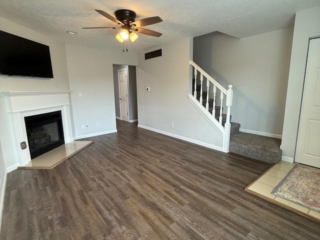 1508 Hancock Dr Unit 1, Normal, IL 61761 - unfurnished living room with a ceiling fan, stairway, wood finished floors, a textured ceiling, and a fireplace with raised hearth