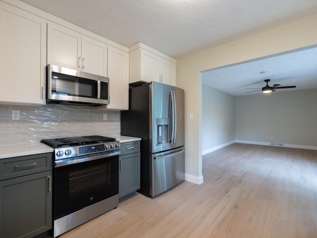 14746 Mercury Ln, Bloomington, IL 61705 - kitchen with appliances with stainless steel finishes, light wood-style flooring, decorative backsplash, light countertops, and a textured ceiling