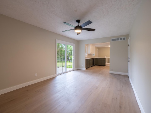 14746 Mercury Ln, Bloomington, IL 61705 - unfurnished living room featuring light wood-style floors, ceiling fan, and a textured ceiling