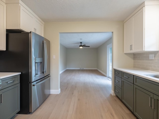 14746 Mercury Ln, Bloomington, IL 61705 - kitchen featuring stainless steel refrigerator with ice dispenser, light wood-style flooring, decorative backsplash, light countertops, and a textured ceiling