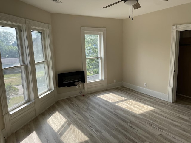 355 N 5th St, Sheldon, IL 60966 - unfurnished living room featuring a ceiling fan, wood finished floors, heating unit, and a fireplace
