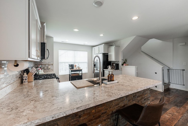 2366 Aurora Dr, Pingree Grove, IL 60140 - kitchen with appliances with stainless steel finishes, a peninsula, light countertops, backsplash, and dark wood-style floors