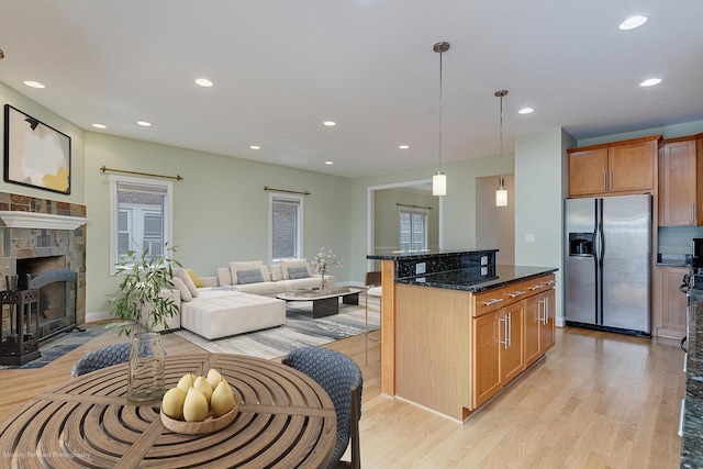 3129 N Oconto Ave, Chicago, IL 60707 - kitchen featuring stainless steel refrigerator with ice dispenser, light wood-type flooring, a breakfast bar, a kitchen island, and recessed lighting