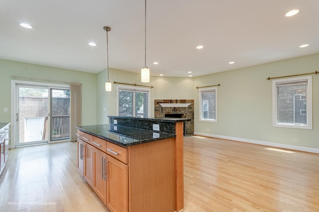 3129 N Oconto Ave, Chicago, IL 60707 - kitchen featuring light wood-type flooring, healthy amount of natural light, a center island, dark stone counters, and recessed lighting