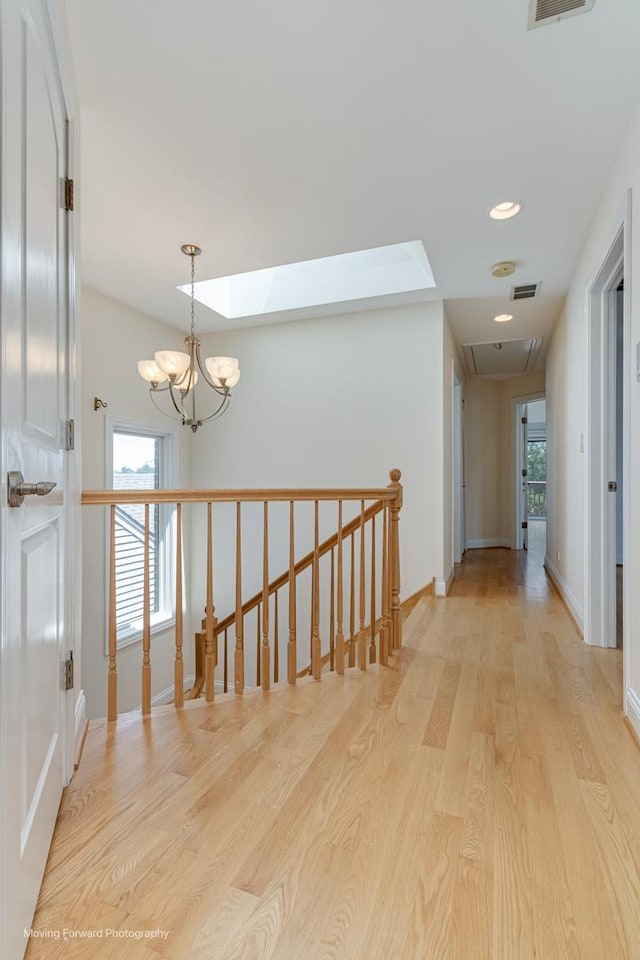 3129 N Oconto Ave, Chicago, IL 60707 - hall featuring an upstairs landing, a skylight, light wood finished floors, a chandelier, and recessed lighting