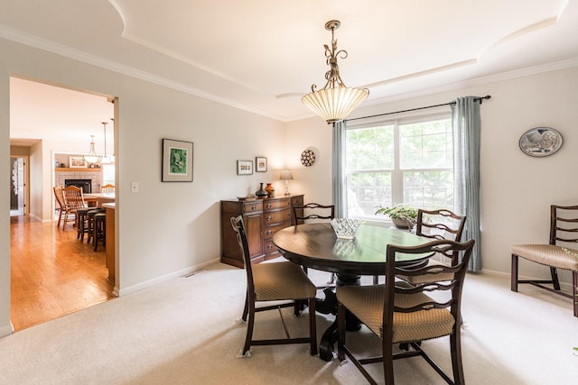 102 Quinlan Ave, Dekalb, IL 60115 - dining area featuring a tray ceiling, light carpet, ornamental molding, and a fireplace