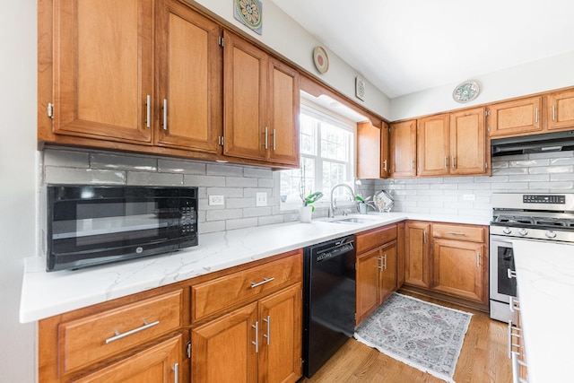 102 Quinlan Ave, Dekalb, IL 60115 - kitchen with black dishwasher, stainless steel range with gas stovetop, under cabinet range hood, brown cabinets, and tasteful backsplash