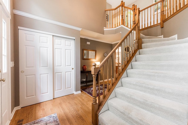 102 Quinlan Ave, Dekalb, IL 60115 - entrance foyer with stairway, wood finished floors, a towering ceiling, and ornamental molding