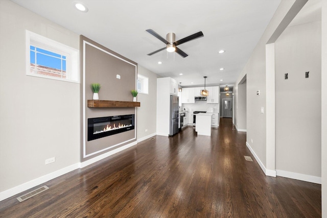 2101 S 48th Ct, Cicero, IL 60804 - unfurnished living room featuring ceiling fan, dark wood-type flooring, a glass covered fireplace, recessed lighting, and plenty of natural light