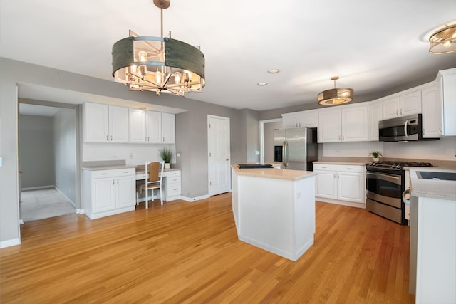401 Kerry Ct, Prospect Heights, IL 60070 - kitchen featuring appliances with stainless steel finishes, built in desk, white cabinetry, a kitchen island, and recessed lighting
