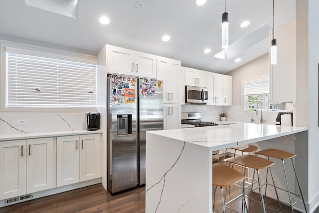 1017 Dell Rd, Northbrook, IL 60062 - kitchen with stainless steel appliances, tasteful backsplash, a skylight, a kitchen breakfast bar, and white cabinetry