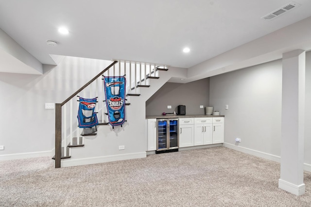 1017 Dell Rd, Northbrook, IL 60062 - indoor dry bar featuring beverage cooler, light carpet, stairs, and recessed lighting