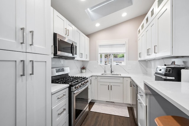 1017 Dell Rd, Northbrook, IL 60062 - kitchen with appliances with stainless steel finishes, lofted ceiling, dark wood-style floors, white cabinetry, and decorative backsplash