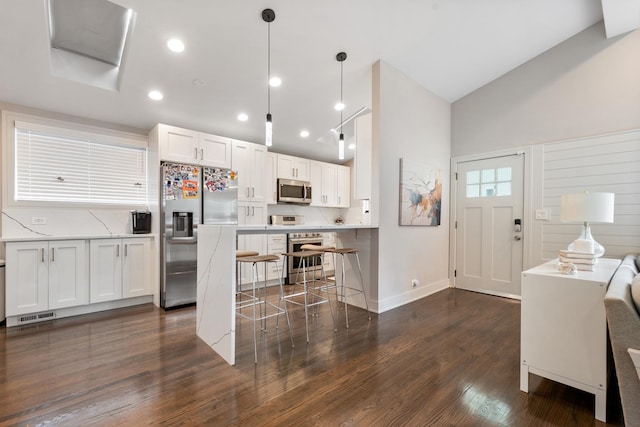 1017 Dell Rd, Northbrook, IL 60062 - kitchen with stainless steel appliances, a breakfast bar, white cabinets, dark wood finished floors, and light countertops