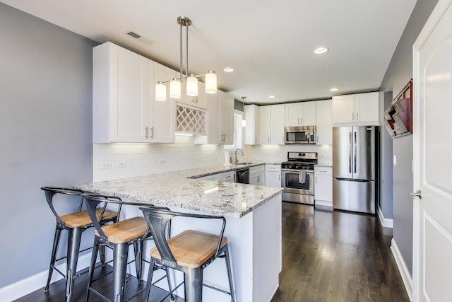 5921 N Navarre Ave, Chicago, IL 60631 - kitchen featuring appliances with stainless steel finishes, a peninsula, white cabinets, and recessed lighting