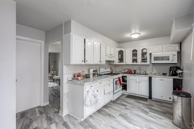 8821 N Washington St Unit F, Niles, IL 60714 - kitchen featuring white appliances, under cabinet range hood, white cabinets, glass insert cabinets, and tasteful backsplash