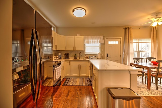 2718 W Washington Blvd, Chicago, IL 60612 - kitchen with black appliances, light stone counters, dark wood-style floors, a ceiling fan, and white cabinets