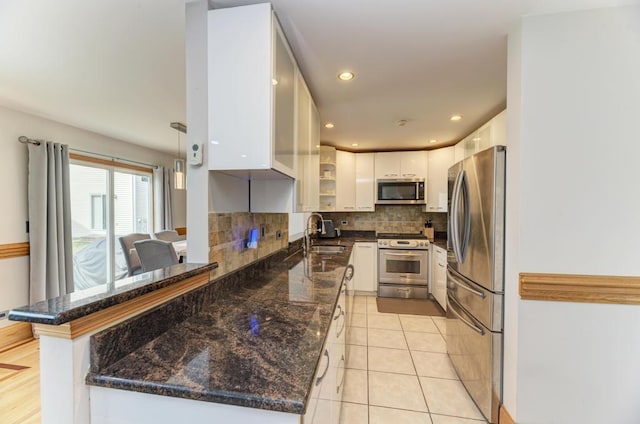 807 Harris Ln Unit 807, Romeoville, IL 60446 - kitchen with stainless steel appliances, a peninsula, white cabinetry, tasteful backsplash, and dark stone countertops